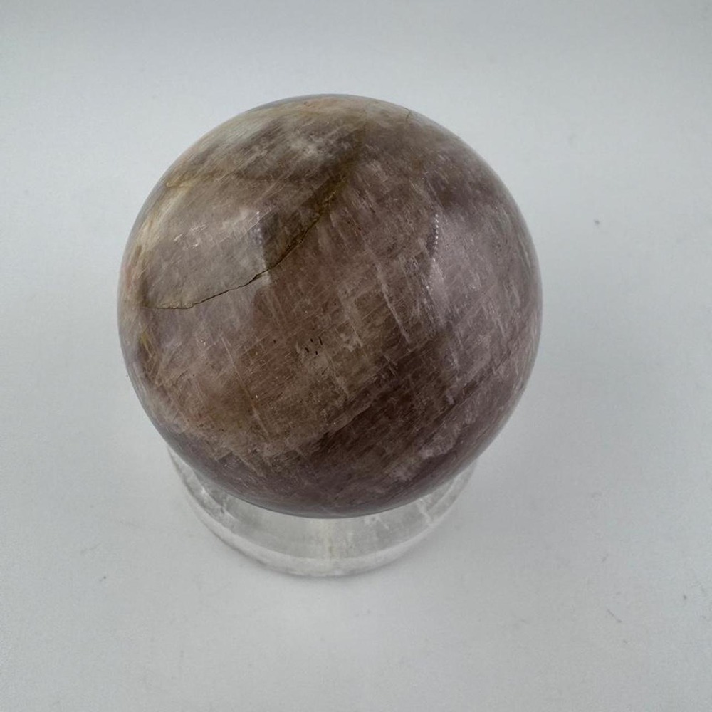 Polished moonstone sphere with small blue flash